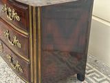 a small chest of drawers sitting on a tiled floor