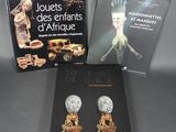 trois livres posés sur une table, à côté d'une statue représentant une femme et d'une autre représentant un homme