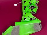 a pair of green shoes that are on a red surface