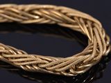 a close up of a gold bracelet on a black surface