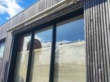 une grande fenêtre équipée de stores, située sur le côté d'un immeuble