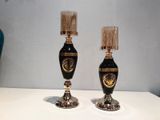 two black and gold vases sitting on a white table