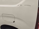 a close up of a white van with a hole in the side of it