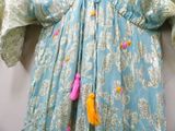 an image of a blue and yellow dress with tassels on it
