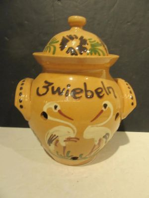 a yellow vase with a lid on a white table