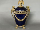 un vase bleu orné d'un motif doré sur le dessus
