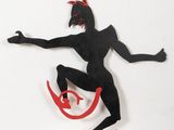 une sculpture noire et rouge représentant un homme sur un skateboard