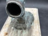 a statue of a man holding a pipe on a wooden base