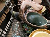 a basket full of vases and bowls on the table
