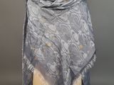 a gray and white shawl with gold stars on it
