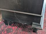 a black dresser sitting on a red rug on the floor