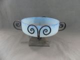 a blue bowl on a stand on a white surface