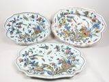 trois assiettes à motifs floraux posées sur une surface blanche