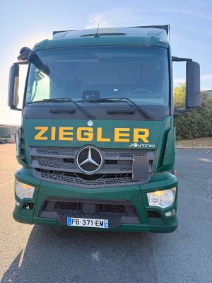 un camion vert garé sur le bord de la route