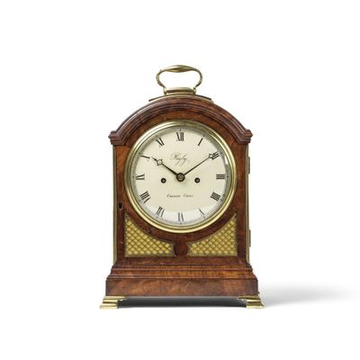 une petite horloge en bois avec des chiffres romains sur le cadran