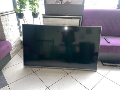une télévision à écran plat posée par terre dans le salon