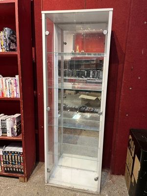 une vitrine en verre dans le coin d'une pièce