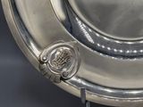 a silver plate with a seal on it on a stand