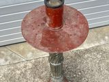 a red candle holder sitting on top of a cement floor