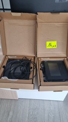 deux cartons contenant des ordinateurs portables, posés par terre