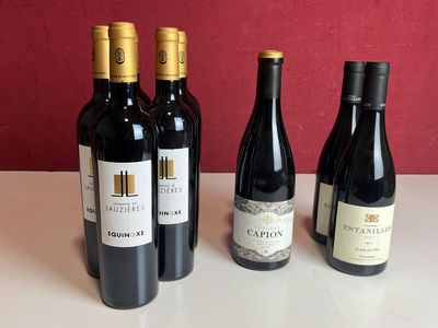 quatre bouteilles de vin sont alignées sur une table