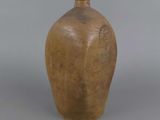 a brown vase sitting on a table with a gray background