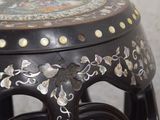 a close up of a black stool with a floral design on it