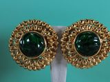a close up of a pair of green earrings on a white stand