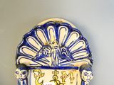 une horloge murale bleue et blanche sur laquelle est représenté un oiseau