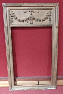 an ornate silver frame with a red wall in the background