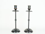 a pair of metal candlesticks on a white background