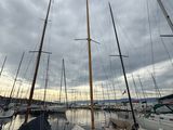 several sailboats are docked in a harbor under a cloudy sky