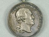 a silver medal with a ribbon around it on a table