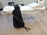 une table blanche sur laquelle est posé un sac noir