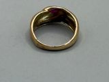 a gold ring with a red stone in it