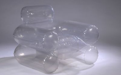 three empty plastic bottles stacked on top of each other on a white surface