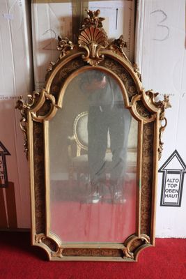 a picture of a gold framed mirror sitting on a red carpet