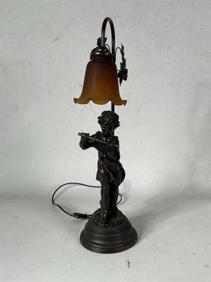 une image représentant une lampe surmontée d'une statue