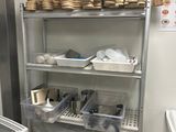 une cuisine avec une étagère remplie de provisions et d'ustensiles