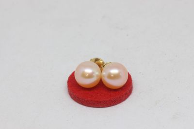 pair of pink pearl earrings on a red sponge