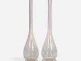 two clear glass vases sitting on top of a white surface