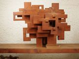 a sculpture made of wood blocks on a wooden shelf