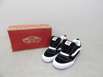 a pair of black and white shoes next to a red box