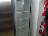 une photo d'un réfrigérateur dans une cuisine, avec un extincteur