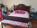 a bed and a bench in a room with wood floors