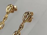 a pair of gold earrings with diamonds on a white surface