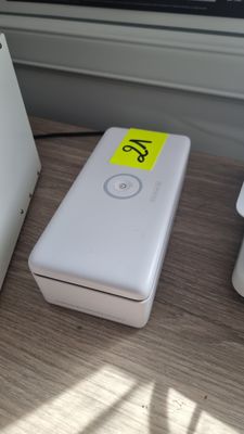 une batterie externe blanche posée sur une table à côté d'un ordinateur portable