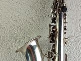 an image of a silver saxophone sitting on top of a white table