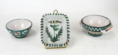 three pieces of pottery sitting on a white surface