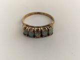 a close up of a gold ring with three oplite stones